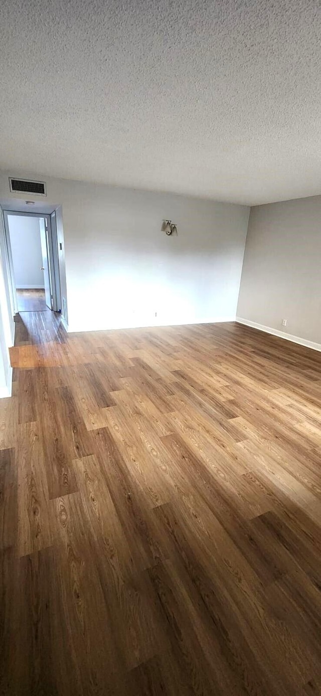 empty room featuring light hardwood / wood-style flooring and a textured ceiling