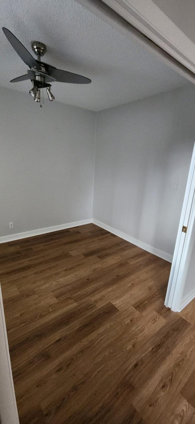 unfurnished room with ceiling fan, dark hardwood / wood-style floors, and a textured ceiling