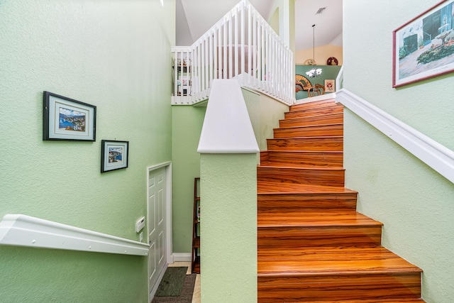 stairway featuring a notable chandelier