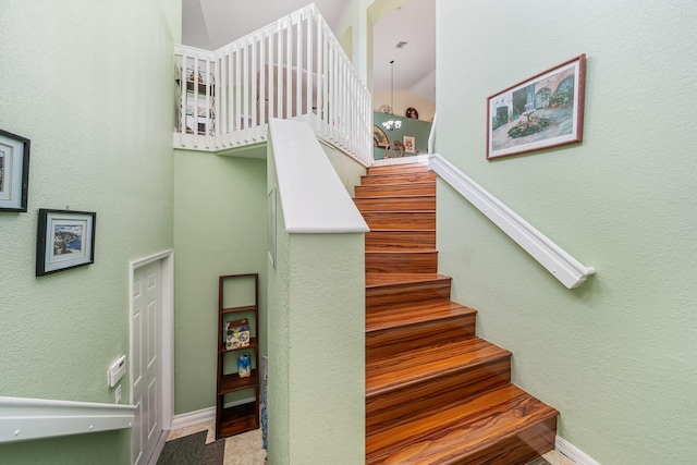 staircase with a chandelier