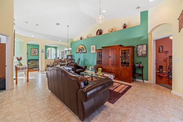 tiled living room with a chandelier and high vaulted ceiling