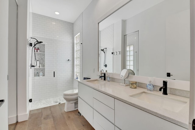 bathroom with toilet, an enclosed shower, vanity, a wealth of natural light, and hardwood / wood-style flooring