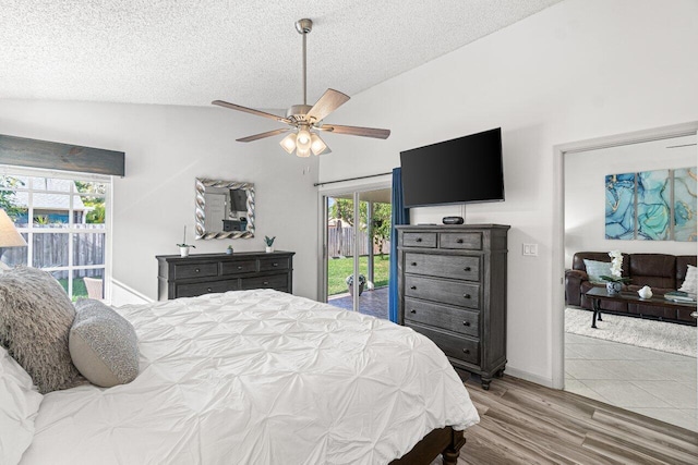 bedroom with vaulted ceiling, access to exterior, ceiling fan, a textured ceiling, and light wood-type flooring