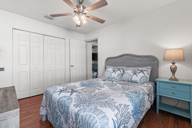 bedroom featuring ceiling fan, dark hardwood / wood-style floors, a closet, and a textured ceiling