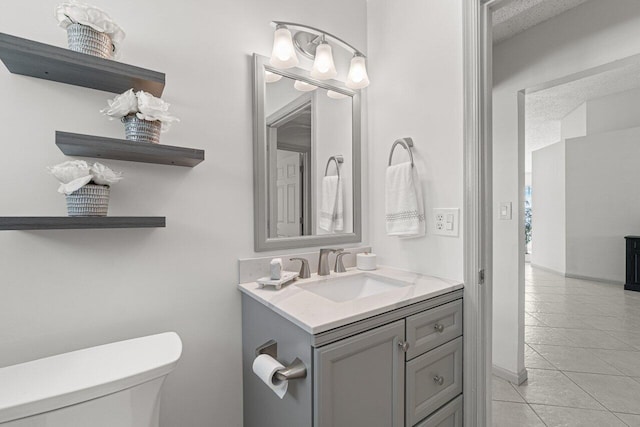 bathroom featuring tile patterned flooring, vanity, and toilet