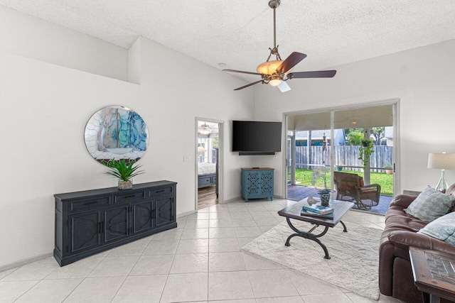 living room featuring ceiling fan, high vaulted ceiling, a textured ceiling, and light tile patterned floors