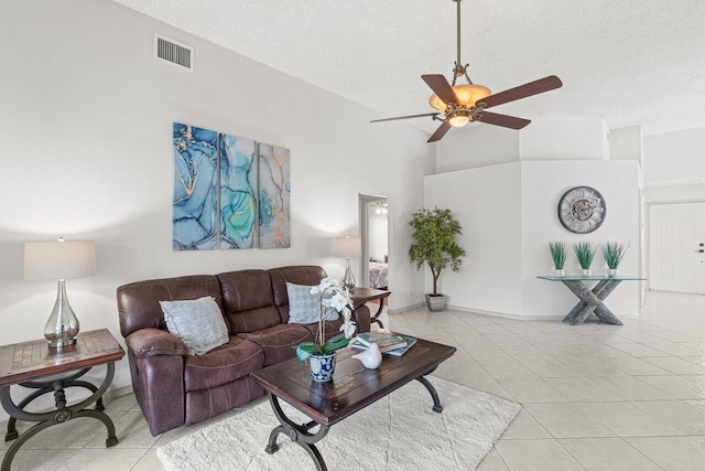 living room with light tile patterned floors, high vaulted ceiling, a textured ceiling, and ceiling fan