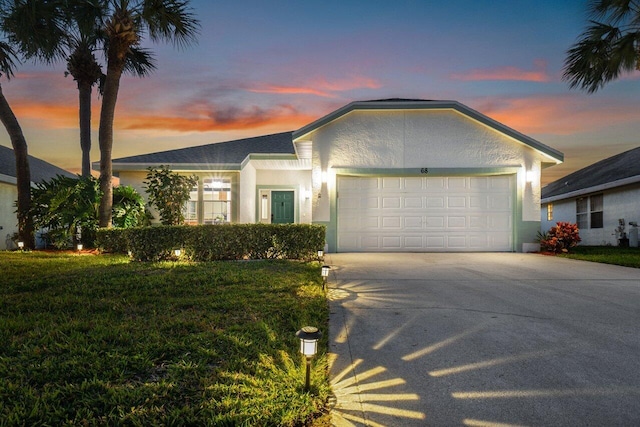 single story home featuring a yard and a garage