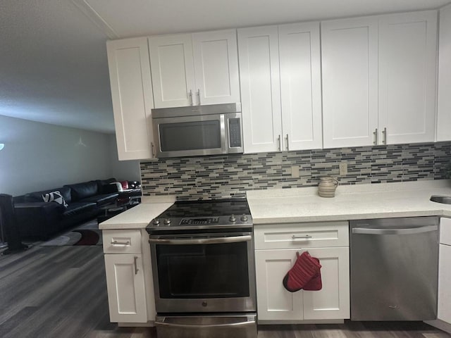 kitchen featuring white cabinetry, stainless steel appliances, dark hardwood / wood-style floors, and tasteful backsplash