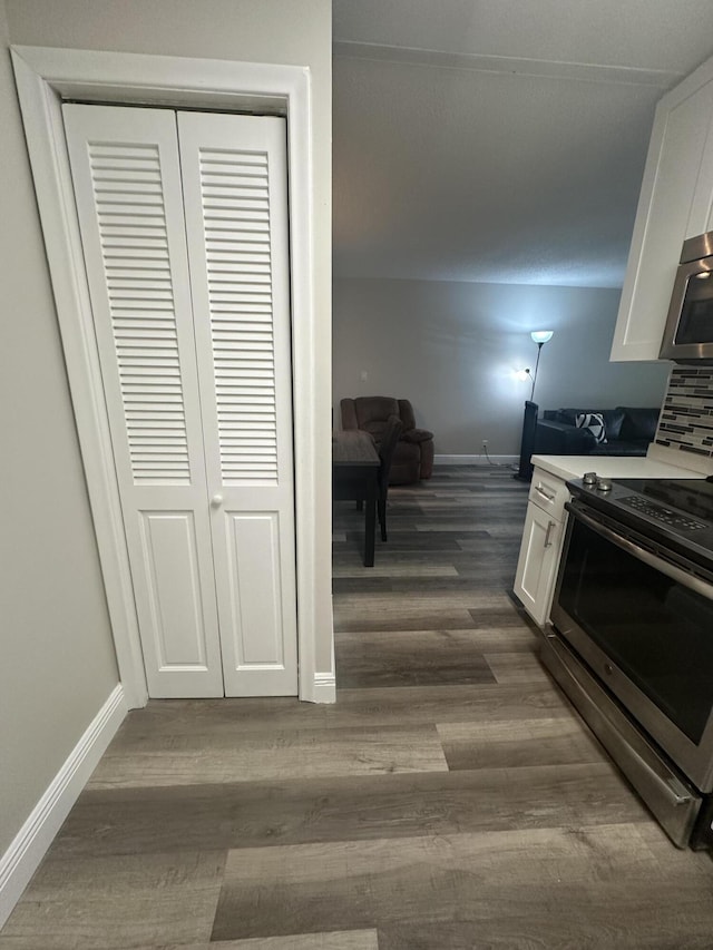 kitchen with tasteful backsplash, stainless steel appliances, dark hardwood / wood-style floors, and white cabinets