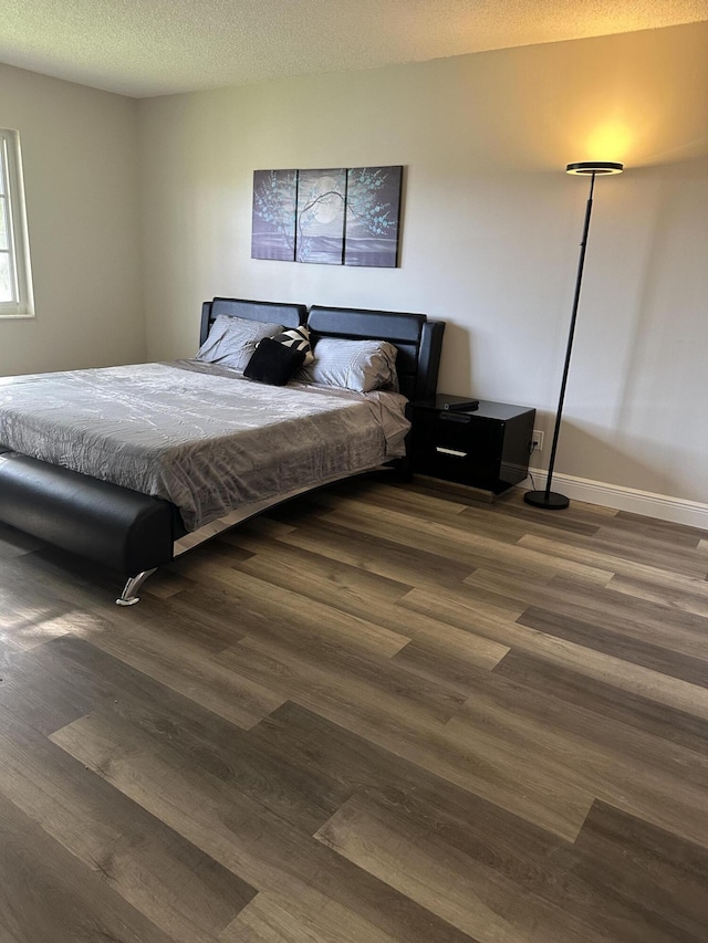 bedroom featuring dark hardwood / wood-style floors and a textured ceiling