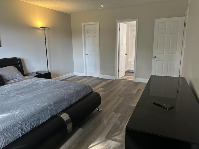 bedroom with dark wood-type flooring and a textured ceiling