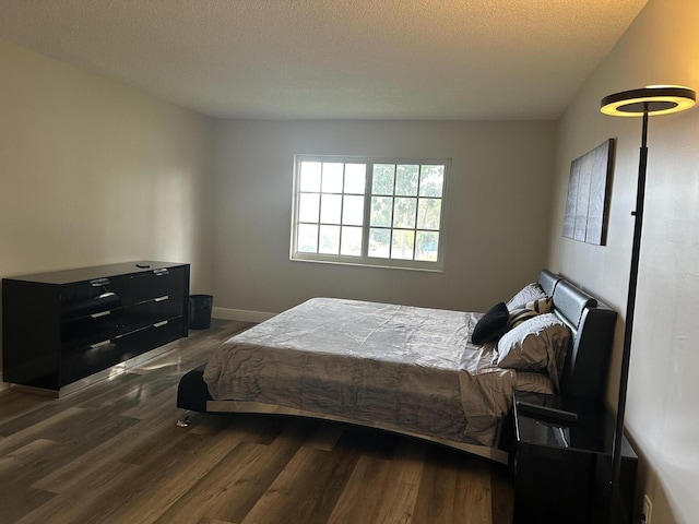 bedroom featuring dark hardwood / wood-style floors and a textured ceiling