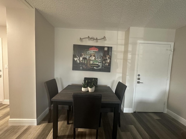 dining space with hardwood / wood-style floors and a textured ceiling