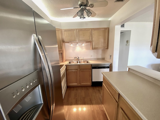 kitchen with sink, appliances with stainless steel finishes, light hardwood / wood-style floors, a textured ceiling, and light brown cabinetry