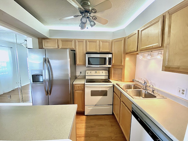 kitchen featuring light brown cabinetry, sink, stainless steel appliances, and light hardwood / wood-style floors