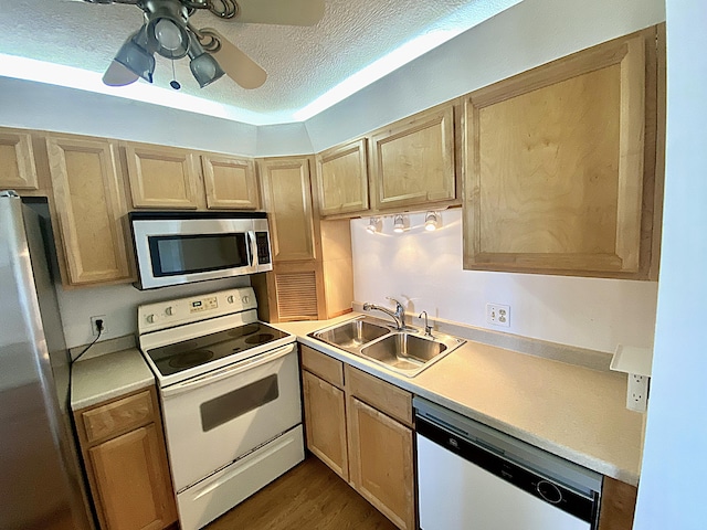 kitchen featuring appliances with stainless steel finishes, sink, ceiling fan, light brown cabinets, and a textured ceiling