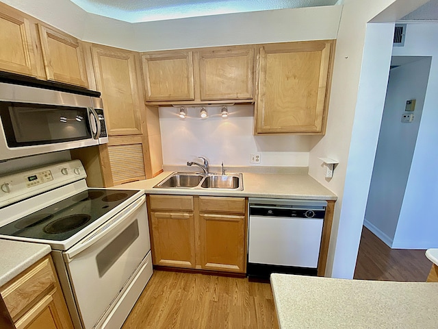 kitchen with white appliances, sink, light hardwood / wood-style flooring, and light brown cabinets