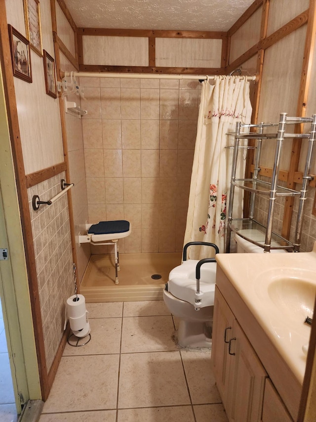 bathroom featuring tile walls, vanity, a textured ceiling, a shower with curtain, and tile patterned floors