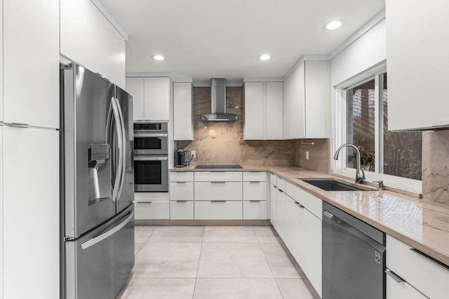 kitchen with wall chimney exhaust hood, sink, tasteful backsplash, black appliances, and white cabinets