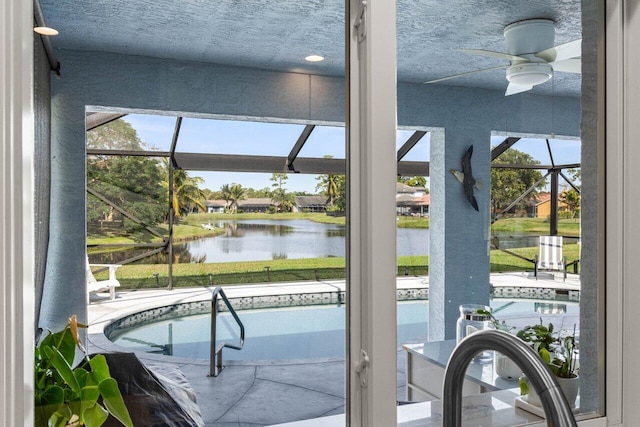 view of pool with a lanai, a patio, and a water view