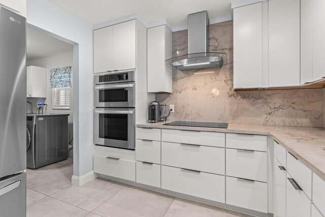 washroom featuring light tile patterned flooring, cabinets, and washer and dryer