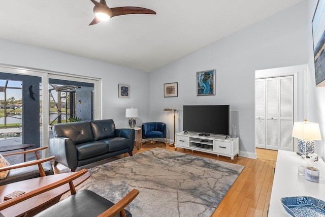 living room featuring lofted ceiling, light hardwood / wood-style flooring, and ceiling fan