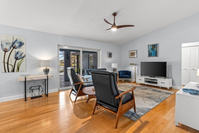 living room with ceiling fan, lofted ceiling, and light hardwood / wood-style floors