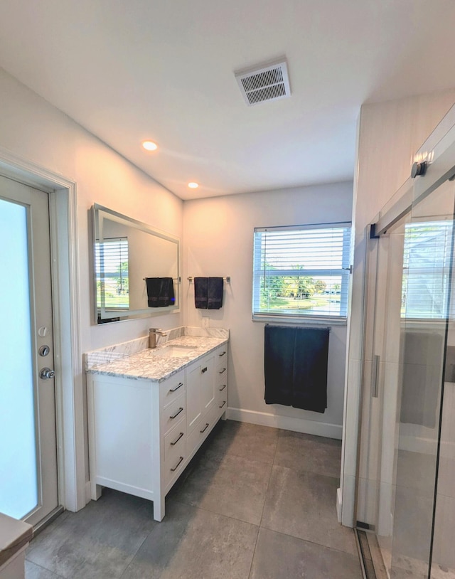 bathroom with tile patterned flooring, vanity, and an enclosed shower