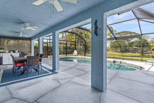 view of swimming pool with a patio, a lanai, and ceiling fan