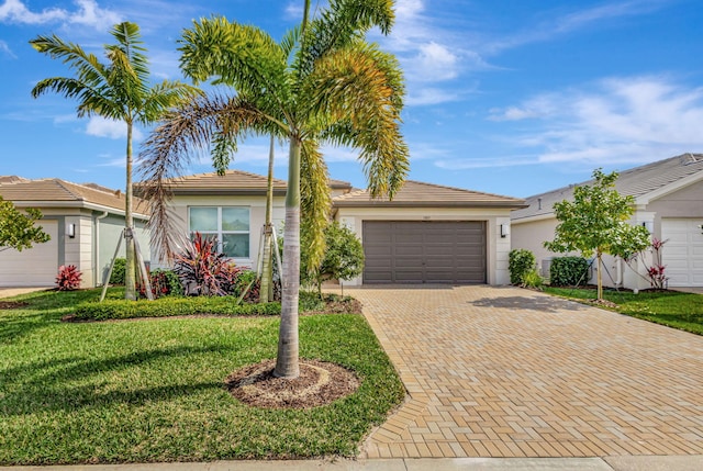 single story home featuring a garage and a front lawn