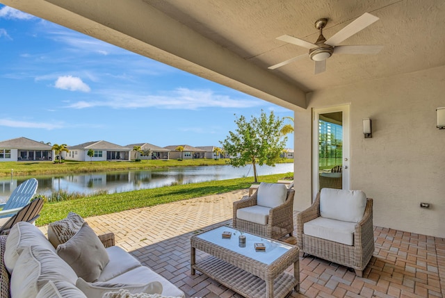 view of patio with a water view, ceiling fan, and an outdoor hangout area