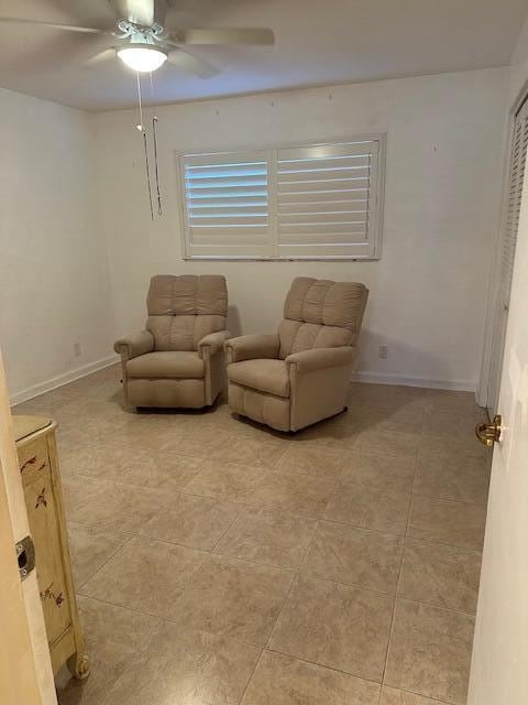 sitting room featuring light tile patterned flooring and ceiling fan