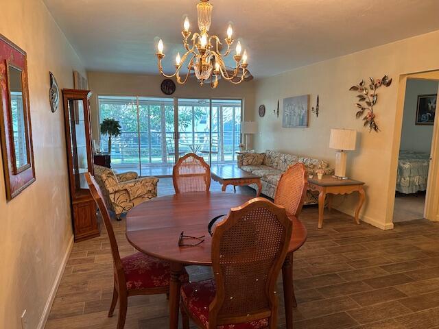 dining space with dark hardwood / wood-style flooring and a chandelier