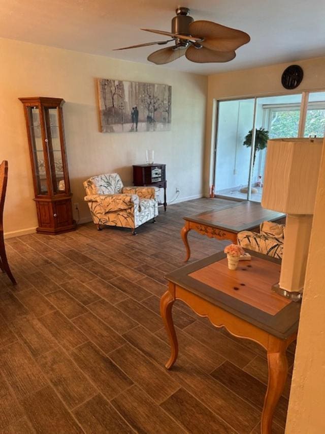 living room featuring ceiling fan and dark hardwood / wood-style flooring