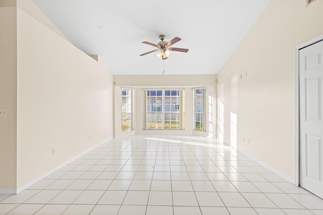 spare room featuring vaulted ceiling, ceiling fan, and light tile patterned flooring