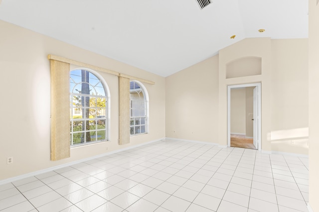 unfurnished room featuring vaulted ceiling and light tile patterned flooring