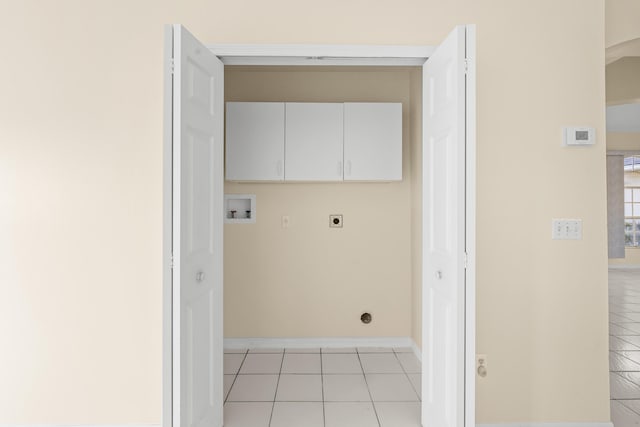 laundry area featuring hookup for a washing machine, electric dryer hookup, light tile patterned floors, and cabinets