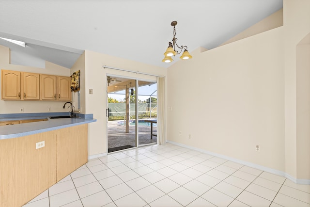 kitchen featuring vaulted ceiling, sink, hanging light fixtures, light tile patterned floors, and light brown cabinets