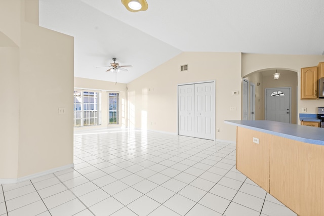 kitchen featuring vaulted ceiling, light brown cabinets, ceiling fan, and light tile patterned floors