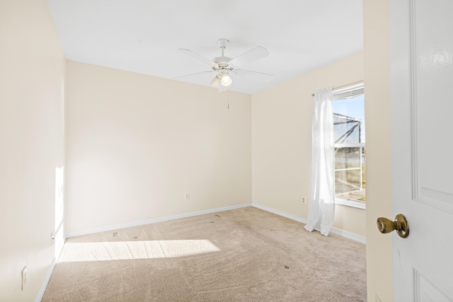 carpeted spare room featuring ceiling fan