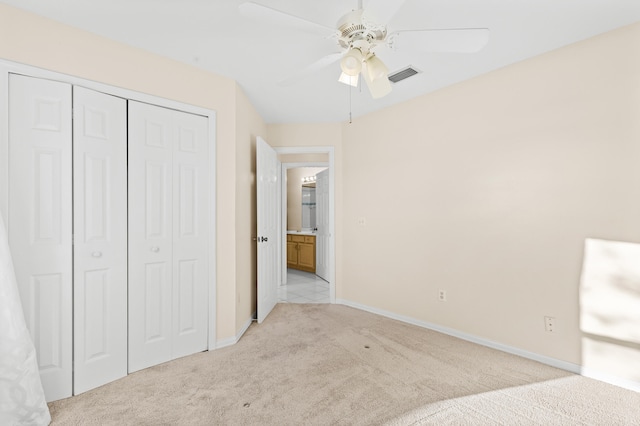 unfurnished bedroom featuring ceiling fan, a closet, and light carpet