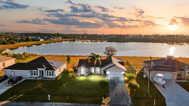 aerial view at dusk featuring a water view