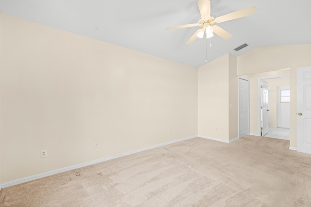 spare room featuring ceiling fan, vaulted ceiling, and light carpet