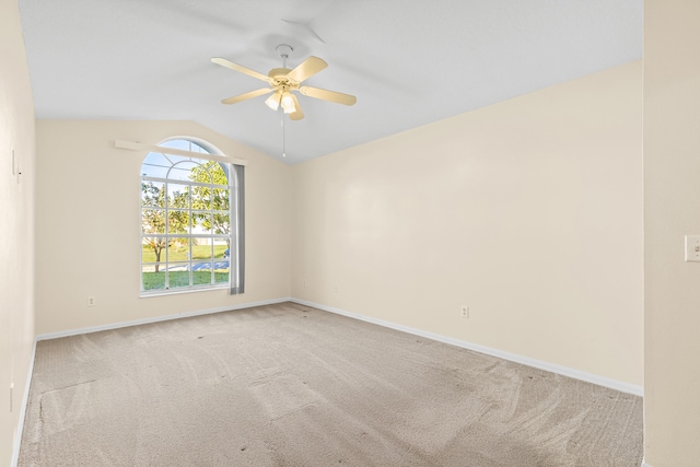 carpeted empty room featuring vaulted ceiling and ceiling fan