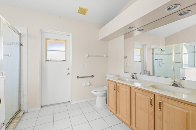 bathroom with toilet, plenty of natural light, tile patterned floors, and a shower with shower door