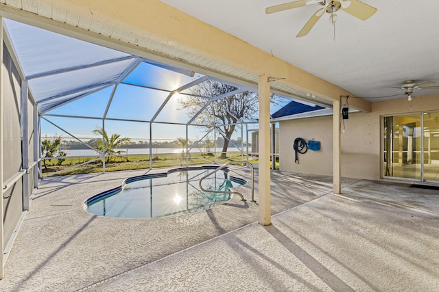 view of pool with ceiling fan, glass enclosure, and a patio area