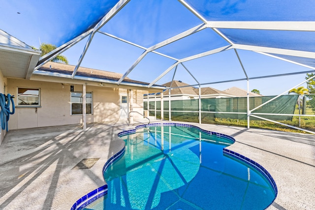 view of swimming pool featuring a patio area and glass enclosure