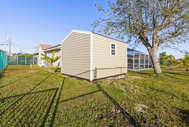 view of side of home with central AC, a yard, and glass enclosure