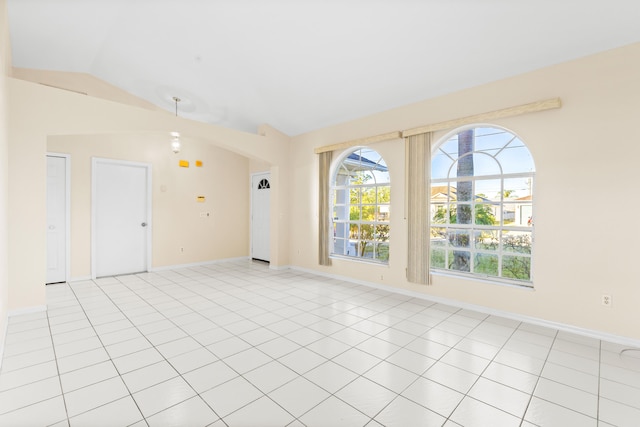 unfurnished room featuring lofted ceiling and light tile patterned floors